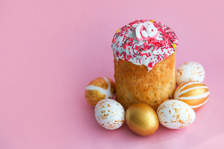 Easter Cakes - Traditional Kulich and golden eggs on a pink background. Paska Easter Bread in...