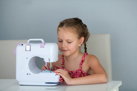 7 years old child studying work with a modern sewing machine. Hobby.の写真素材