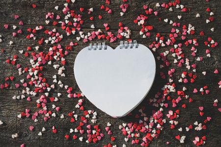 Heart shaped notepad on wooden background. Valentines Day. Copy space. Mockup.の写真素材