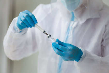 Doctor, researcher hand in blue rubber gloves holds vaccine against influenza, measles, coronavirus,...