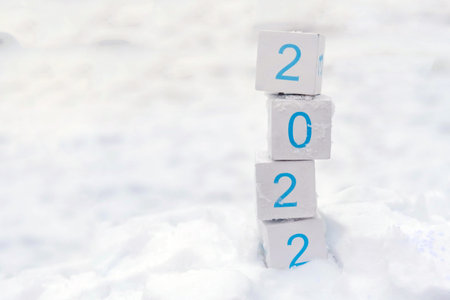 Cubes with year 2022 on a white snow background. Copy space for display of product for promotion on...