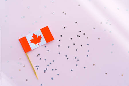 Canada flag and sparkles on pink background, flat lay. Holiday in Canada. 1th of July, Canada's Happy Independence Day. Copy space for text.の写真素材