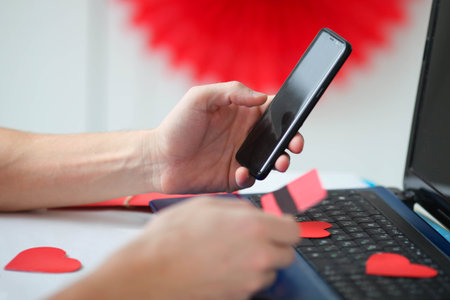 A man holds a mobile phone and a credit card in his hands. online shopping. Valentine's day gifts....