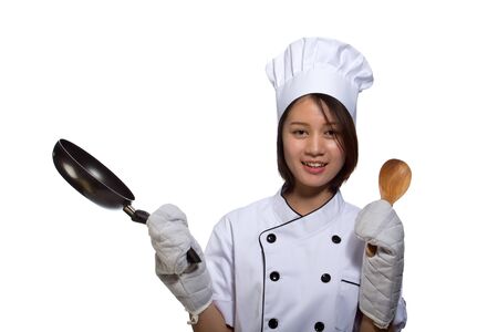 female cook in white uniform and hat keeping frying panの写真素材