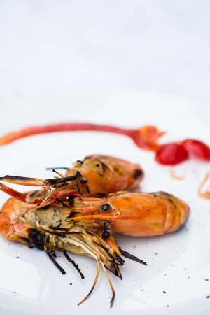 Grilled shrimp on a large white plate.の写真素材
