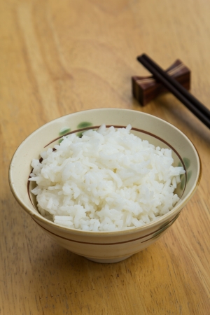 Steamed rice in bowl and chopsticks.の写真素材