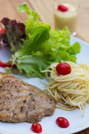 Eating pork steak with spaghettiの写真素材
