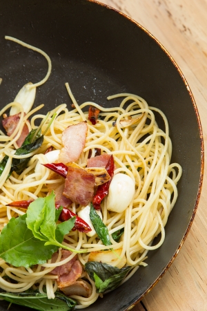 spaghetti with bacon in the pan and herbの写真素材