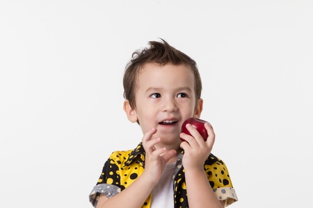 little boy with apple on a white backgroundの写真素材