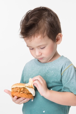 Handsome boy eating a big burger.の写真素材