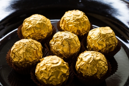 Round chocolate wrapped in gold foil の写真素材