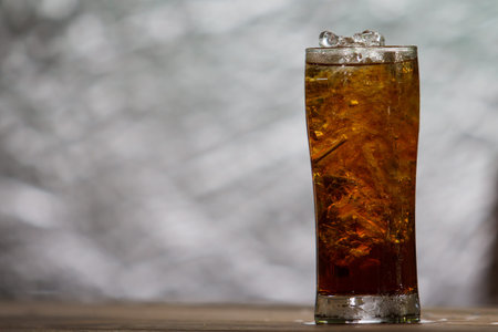 A glass of cola with ice cubes