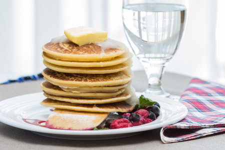Pancakes with berries on a white plate.