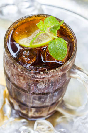 A glass of cola with ice cubesの写真素材