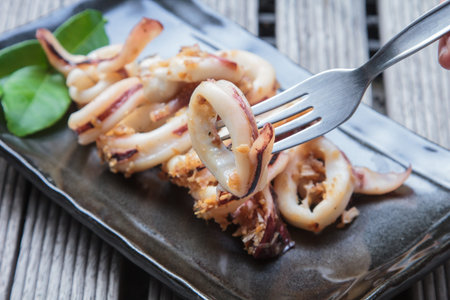 barbecue grilled squid and sliced on black plateの写真素材