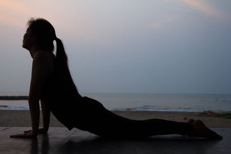Yoga woman on the beautiful beach at sunriseの写真素材