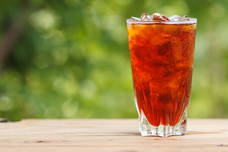 Glass of ice tea on a wooden tableの写真素材