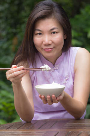 Beautiful young women  are eating rice in restaurantの写真素材