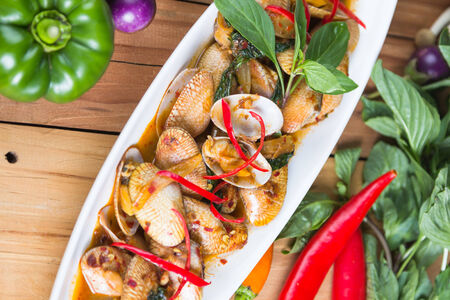 thai style Fried Baby Clam and vegetable on wooden tableの写真素材