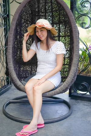 asian women sit on rattan hanging chairのeditorial素材