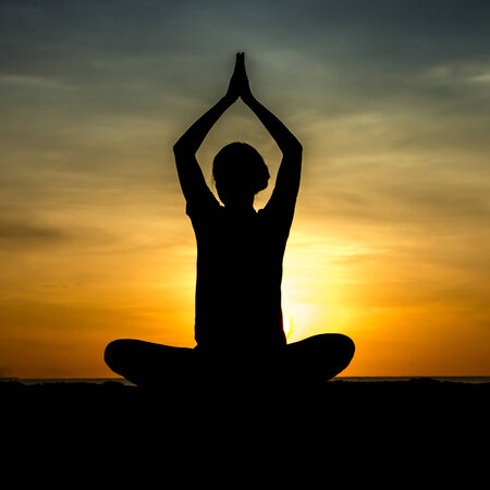 women playing yoga at beachside on sunsetの写真素材