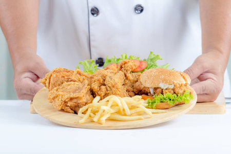 chef showing american food set in wooden plateの写真素材
