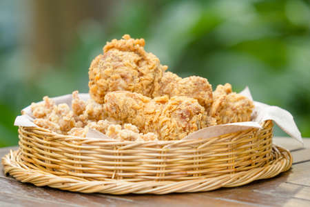 close up fried chicken in basket on wooden tableの写真素材