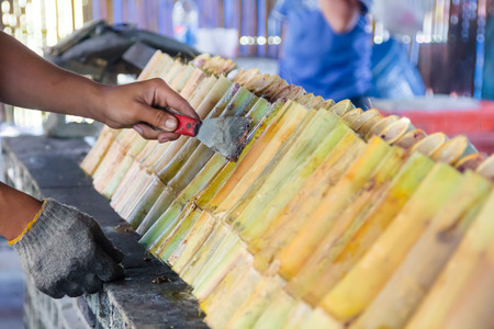 man hand cooking Glutinous rice roasted in bamboo name is khoalamの写真素材