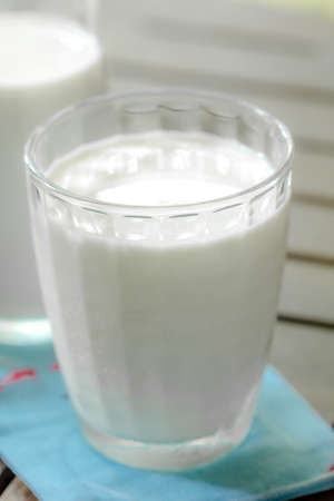 milk glass on wooden tableの写真素材