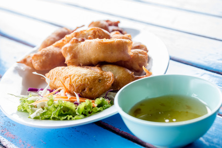 Fried prawn balls with sweet sauce on wooden tableの写真素材