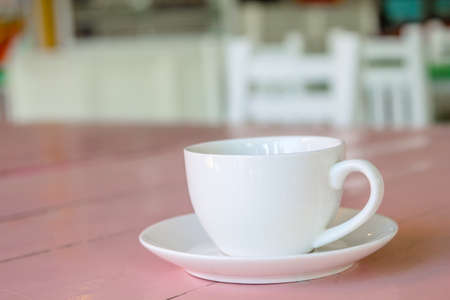 white coffee cup on pink wooden tableの写真素材