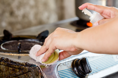 women hand cleaning to the stove in kitchenの写真素材