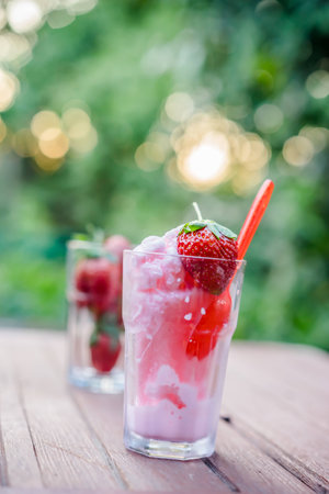 strawberry smoothie in glass on woodenの写真素材