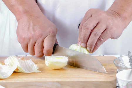 Chef sliced onions on a wooden cutting board.の写真素材