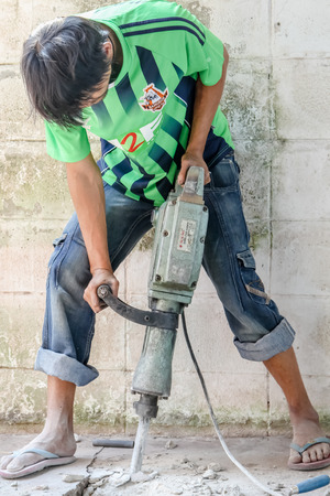 Builder worker with pneumatic hammer drill equipment at construction siteのeditorial素材