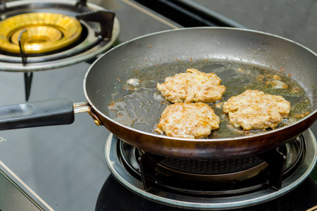 chef frying pork burger in the kitchen