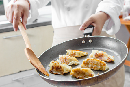 chef making Gyoza (Japanese Dumplings)  in frying panの写真素材
