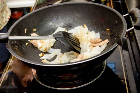 chef making stir-fried Noodles with pork in frying panの写真素材