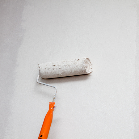 house painter using a paint roller paint in wallの写真素材