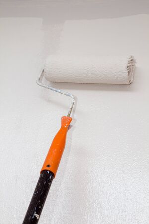 house painter using a paint roller paint in wallの写真素材