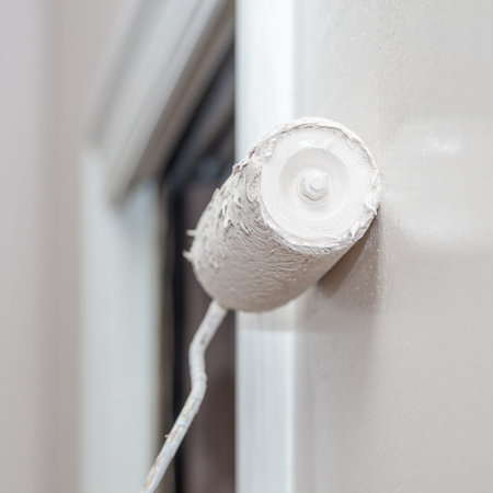 house painter using a paint roller paint in wall
