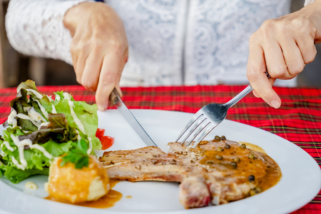 women eating Pork chop steak in steak shopの写真素材