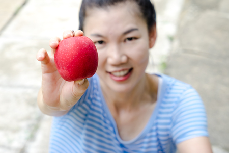 close up women smile and holding red appleの写真素材