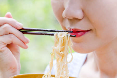 women hand using chopstick eating noodleの写真素材