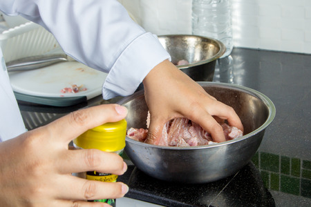 chef marinated raw chicken in bowlの写真素材