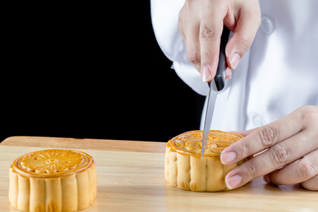 chef cutting for Serving  Mooncake is chinese dessert for Chinese mid autumn festivalの写真素材