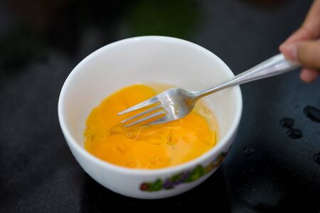 cracking an egg in a glass bowlの写真素材