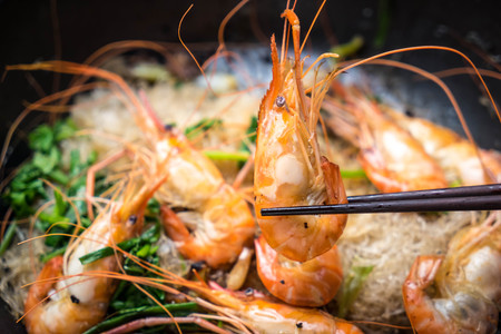 Shrimp baked with vermicelli in pan place on woodenの写真素材