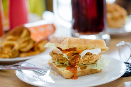 Waffles sandwich with fried chicken in white plateの写真素材
