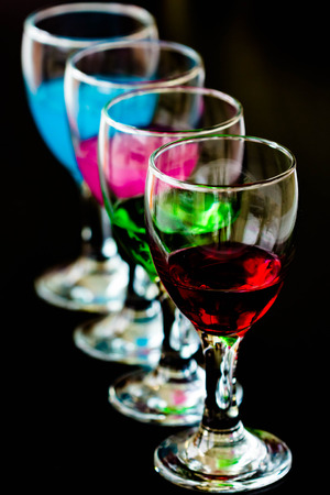 close up colourful cocktail into glass on black backgroundの写真素材